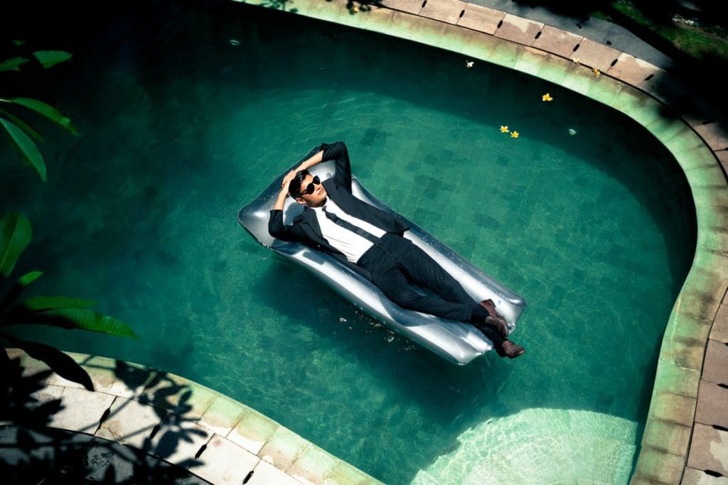 image of a man relaxing in the pool without worrying about any problems in life