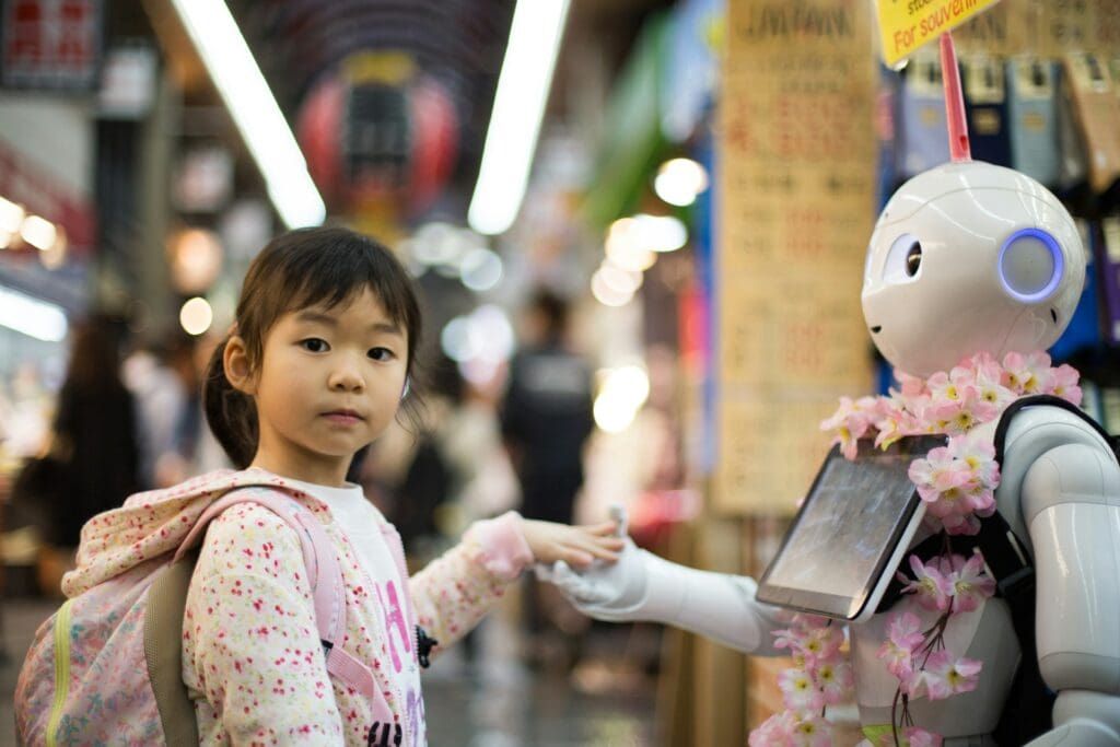 Young girl holding small robot, symbolizing AI mimicking human cognition